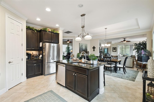 kitchen featuring a center island with sink, pendant lighting, ornamental molding, dark brown cabinets, and appliances with stainless steel finishes