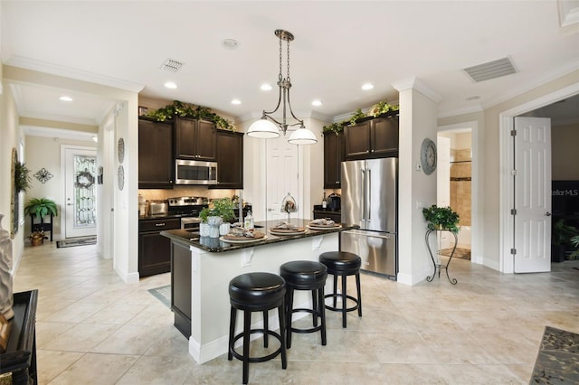 kitchen featuring stainless steel appliances, a kitchen island, dark brown cabinets, pendant lighting, and decorative backsplash