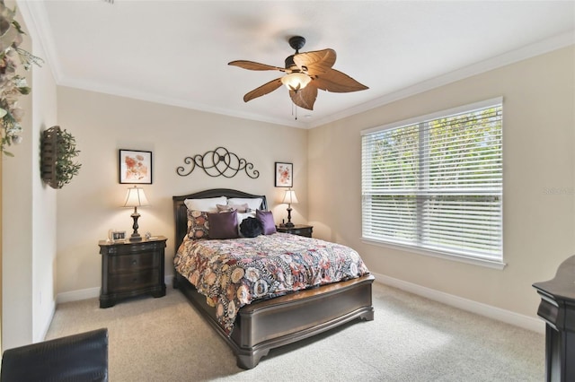 carpeted bedroom featuring ceiling fan and crown molding