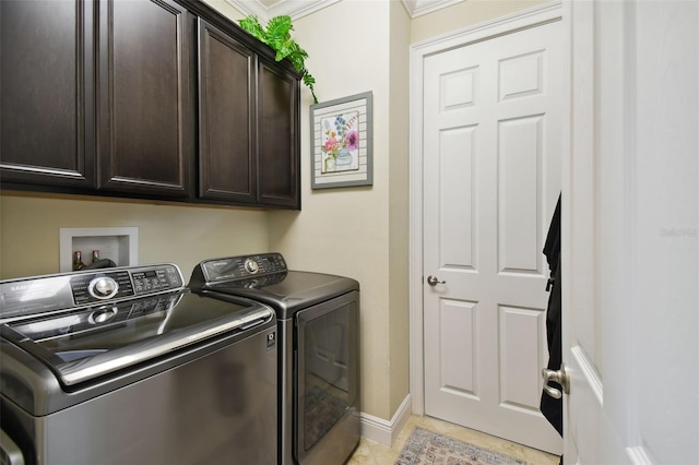 laundry room with cabinets, washing machine and dryer, light tile patterned floors, and crown molding