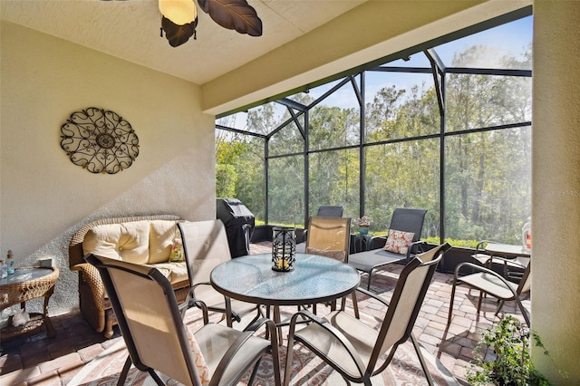 view of patio featuring ceiling fan, glass enclosure, and grilling area