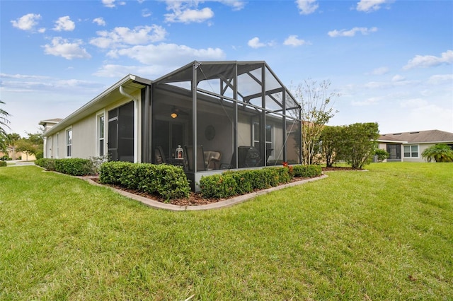 back of property with glass enclosure and a lawn