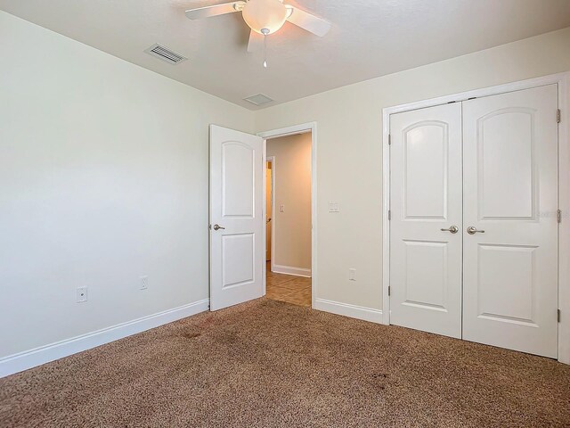 unfurnished bedroom with carpet floors, ceiling fan, and a closet