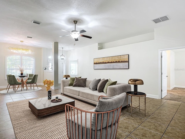 tiled living room with ceiling fan and a textured ceiling