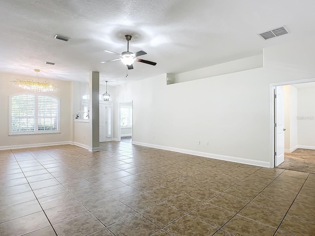 spare room with dark tile patterned flooring, a textured ceiling, and ceiling fan