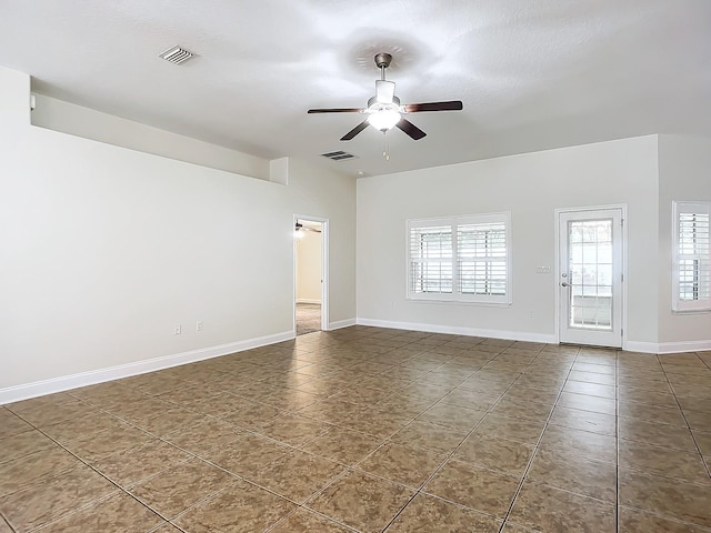 tiled spare room with ceiling fan