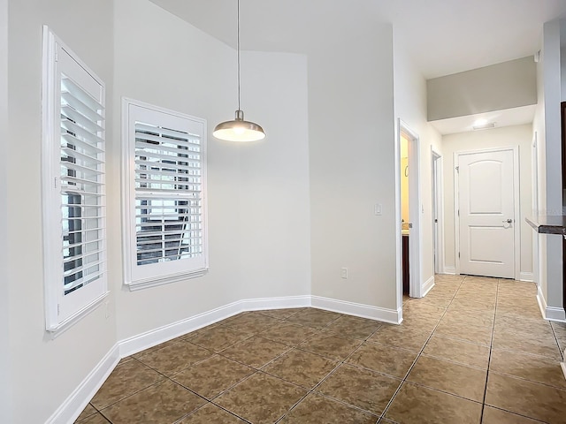 unfurnished dining area with dark tile patterned floors