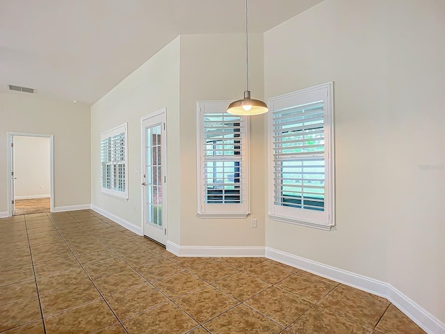 unfurnished dining area featuring a high ceiling, a wealth of natural light, and tile patterned floors