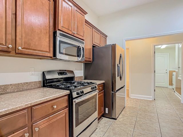 kitchen with stainless steel appliances and light tile patterned flooring