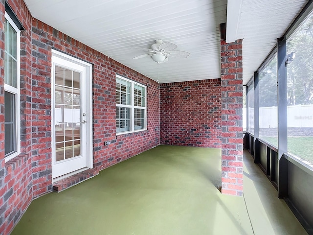 unfurnished sunroom with ceiling fan