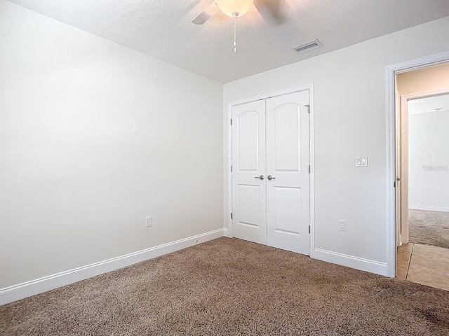 unfurnished bedroom with carpet, ceiling fan, and a closet