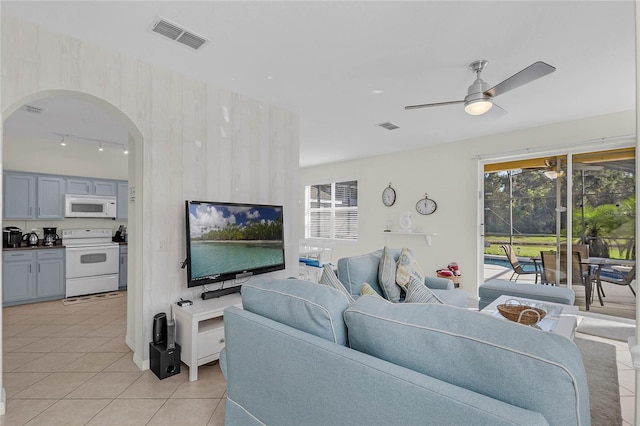 tiled living room with ceiling fan and rail lighting