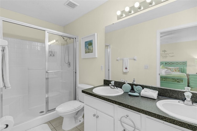 bathroom featuring tile patterned flooring, an enclosed shower, vanity, and toilet