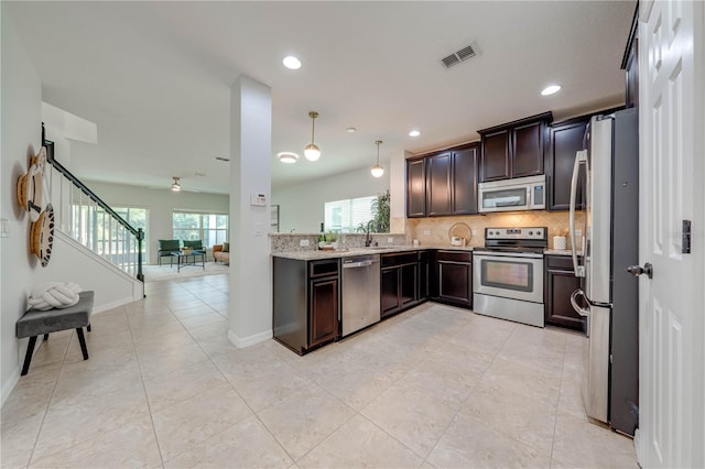 kitchen with decorative backsplash, light tile patterned floors, decorative light fixtures, dark brown cabinets, and stainless steel appliances