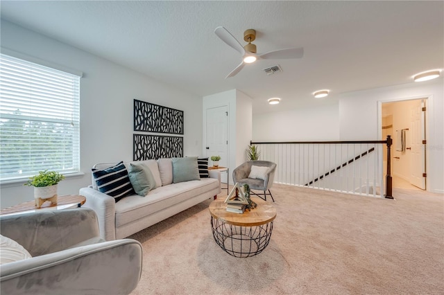 carpeted living area with a ceiling fan and visible vents