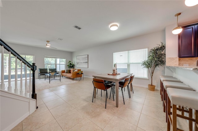 dining room with stairs, ceiling fan, visible vents, and light tile patterned floors