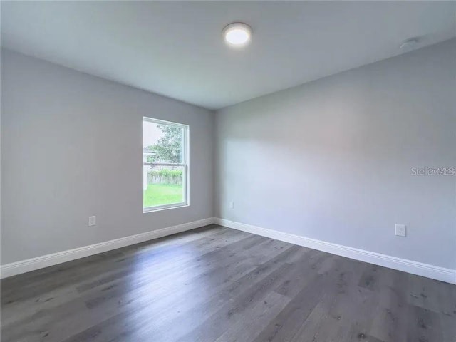 unfurnished room with dark hardwood / wood-style flooring