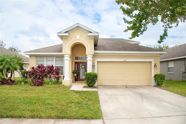 view of front of house with a front yard and a garage