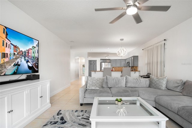 living room featuring a textured ceiling, light tile patterned flooring, and ceiling fan