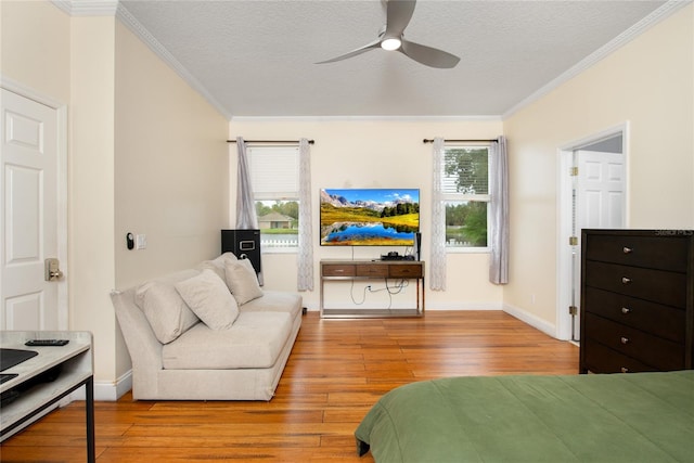 bedroom featuring light hardwood / wood-style floors, crown molding, a textured ceiling, and ceiling fan