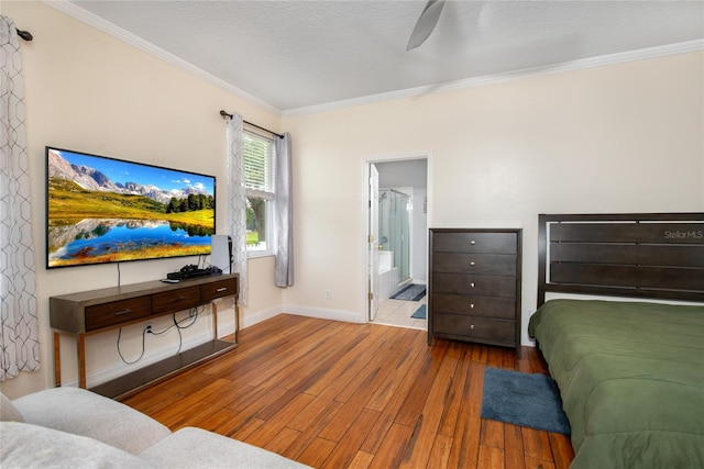 bedroom with a textured ceiling, ceiling fan, connected bathroom, hardwood / wood-style flooring, and ornamental molding