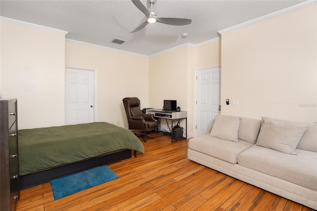 bedroom featuring ornamental molding, a textured ceiling, wood-type flooring, and ceiling fan