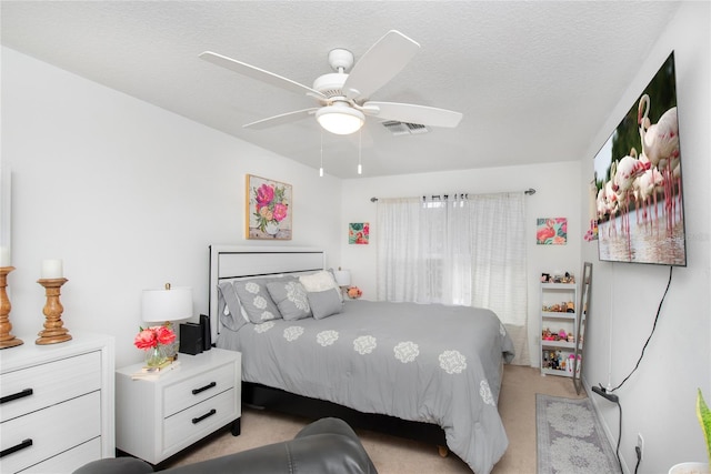 bedroom with light carpet, a textured ceiling, and ceiling fan