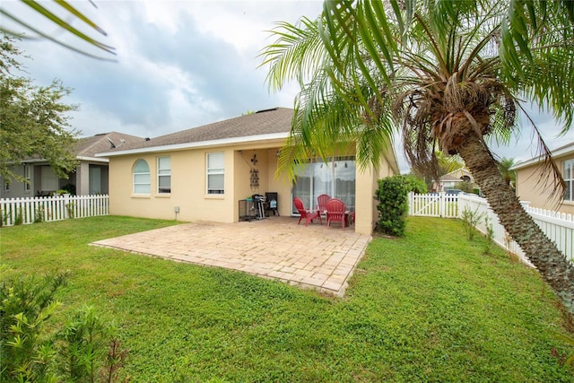 back of property with a patio area and a lawn