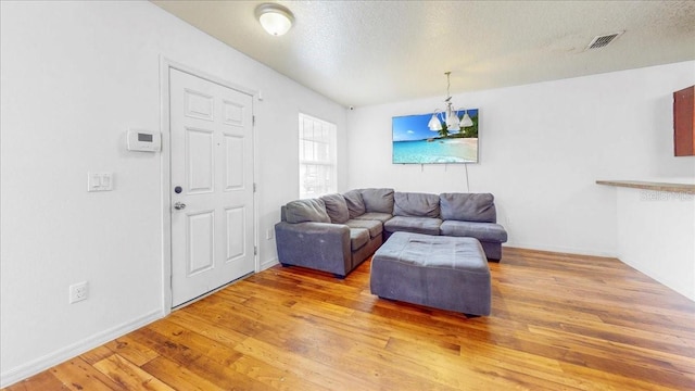 living room with wood-type flooring and a textured ceiling