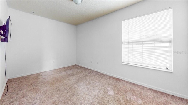 carpeted spare room featuring a textured ceiling