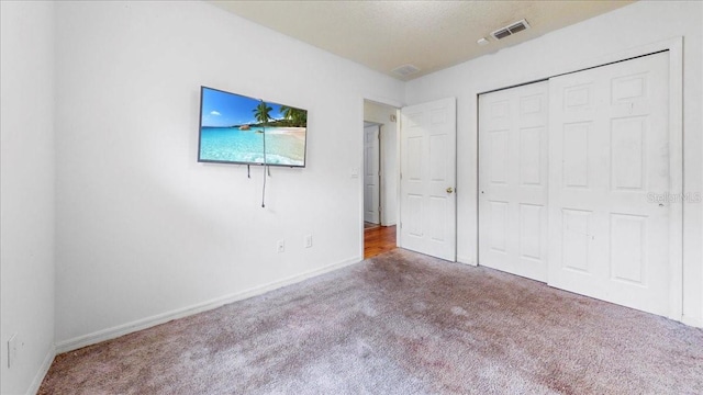 unfurnished bedroom featuring carpet flooring and a closet