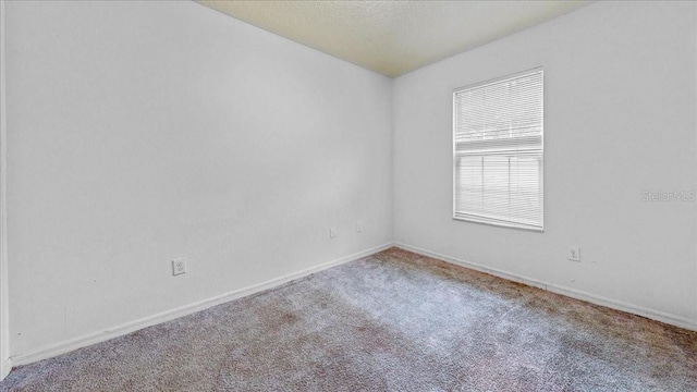 carpeted empty room with a textured ceiling