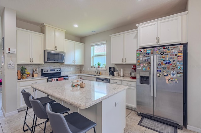 kitchen featuring white cabinets, a kitchen island, and stainless steel appliances