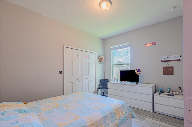 bedroom with a closet and light hardwood / wood-style flooring