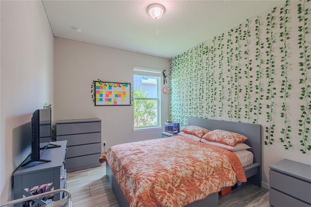 bedroom featuring hardwood / wood-style floors and a textured ceiling