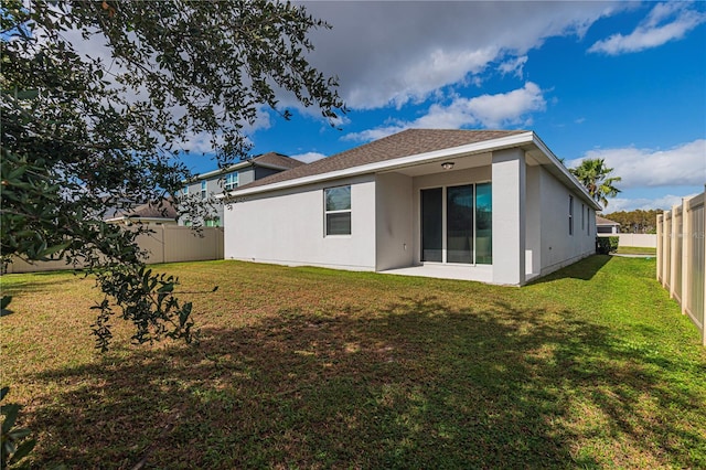 rear view of property with a yard