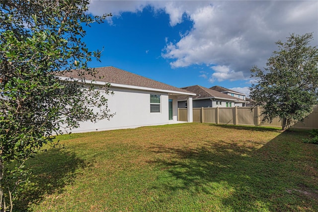 rear view of property with a yard