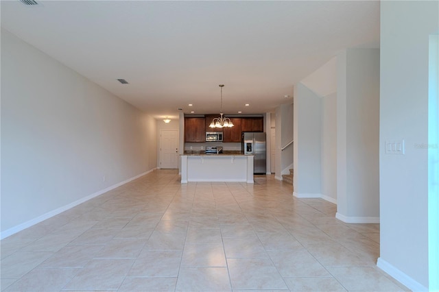 unfurnished living room featuring a chandelier and light tile patterned floors