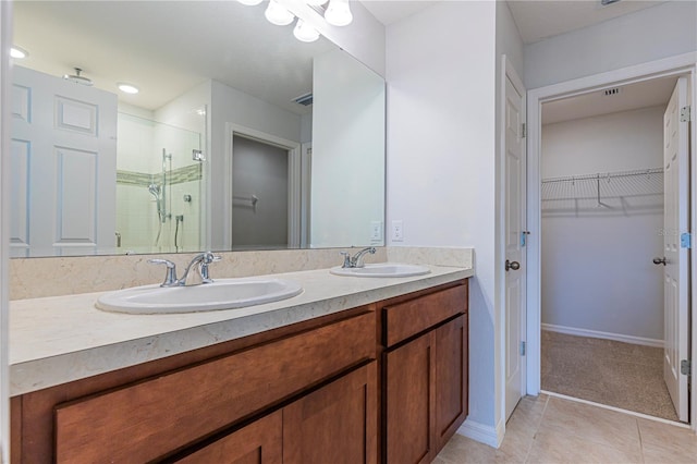 bathroom with tile patterned flooring, vanity, and a shower with door