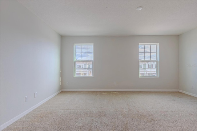 unfurnished room with light carpet and a textured ceiling