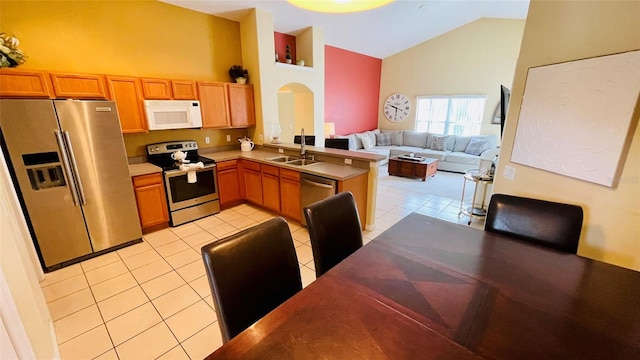 kitchen featuring high vaulted ceiling, sink, light tile patterned floors, and stainless steel appliances