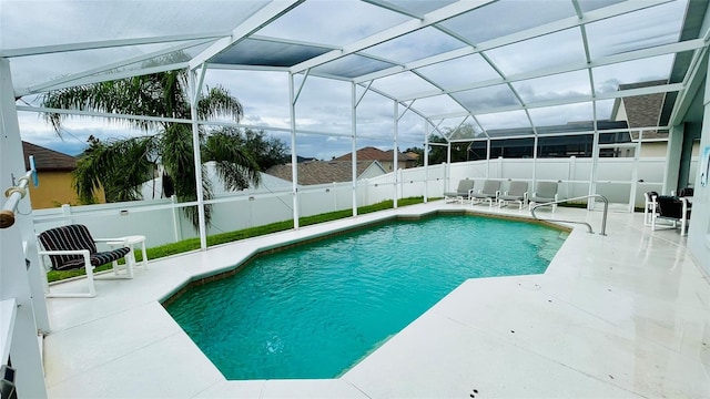 view of swimming pool featuring a lanai and a patio