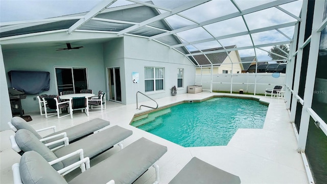 view of pool featuring ceiling fan, glass enclosure, and a patio area