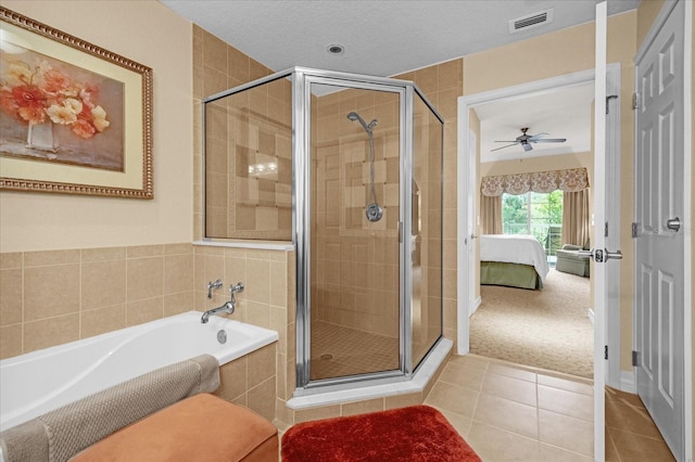 bathroom featuring ceiling fan, tile patterned flooring, shower with separate bathtub, and a textured ceiling