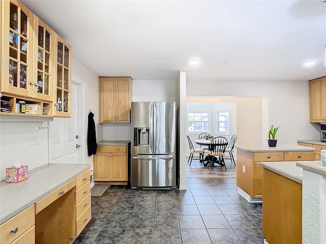 kitchen featuring stainless steel refrigerator with ice dispenser, light brown cabinetry, and dark tile patterned flooring