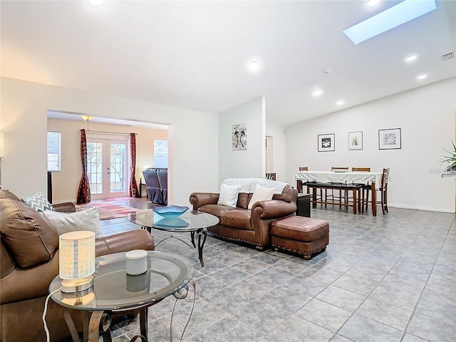 living room with vaulted ceiling with skylight and french doors