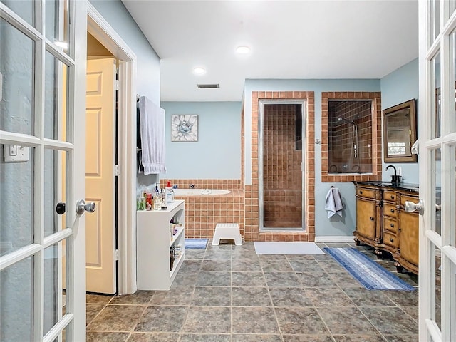 bathroom featuring tile walls, vanity, and separate shower and tub