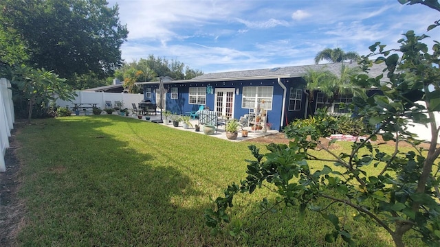 rear view of house with a lawn and a patio