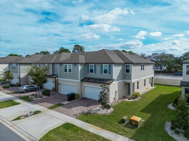 15109 Willow Arbor Cir, Orlando, FL 32824 - view of property featuring decorative driveway, an attached garage, stucco siding, and a residential view