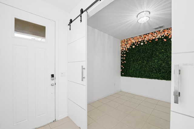 tiled foyer entrance with a barn door